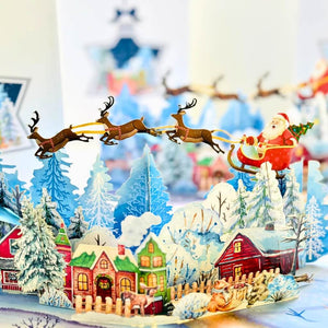 Snowy Village with Flying Santa on Sleigh & Reindeers Pop Card