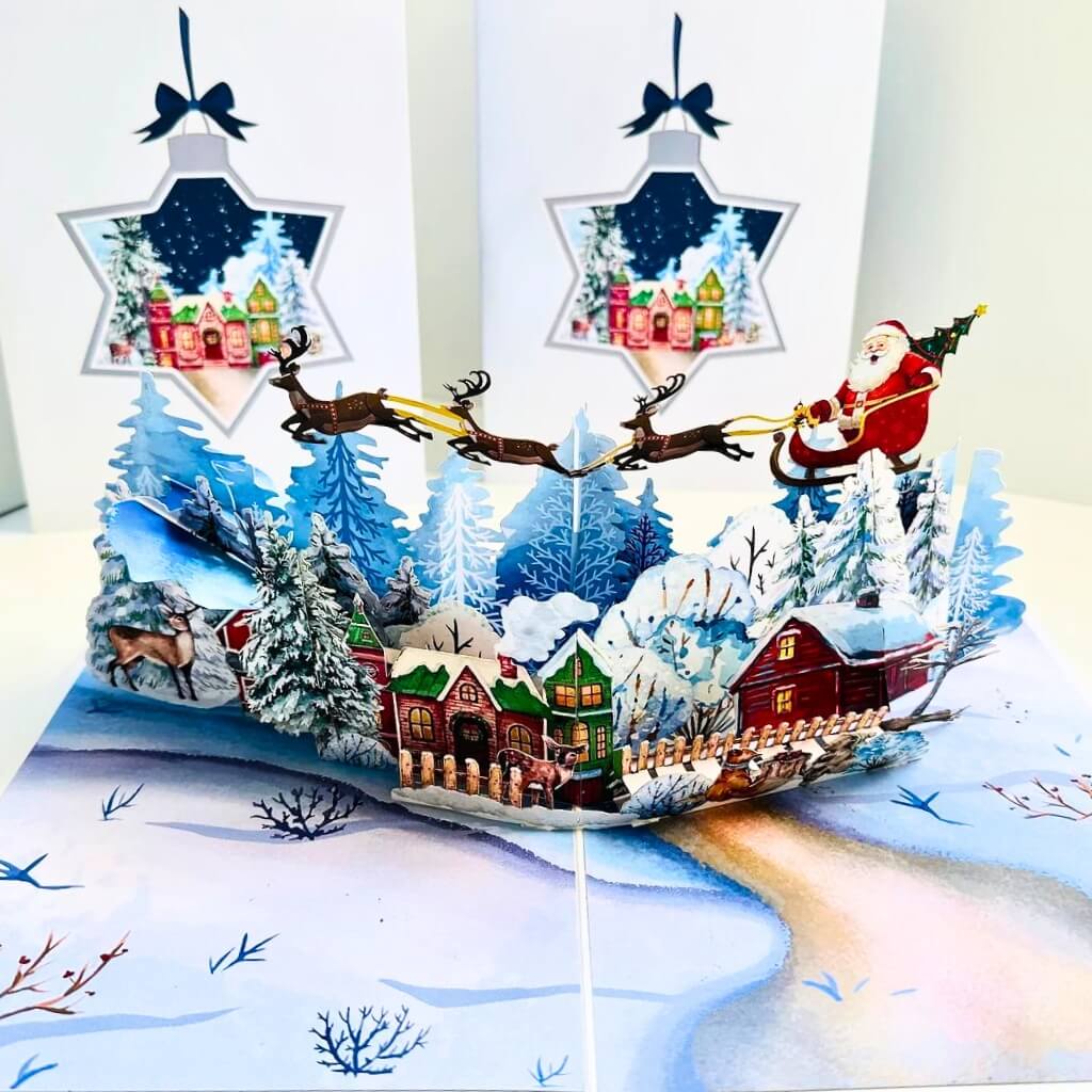 Snowy Village with Flying Santa on Sleigh & Reindeers Pop Card