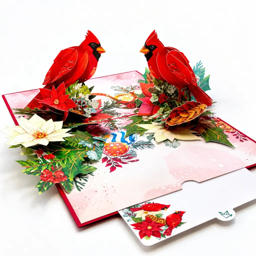 Red cardinal birds surrounded by poinsettias on a Christmas card