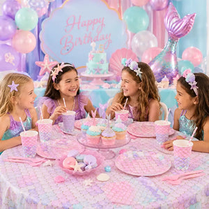 Children at a birthday party with mermaid-themed decorations and tableware.