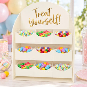White Treat Yourself lolly stand with gold lettering and nine boxes